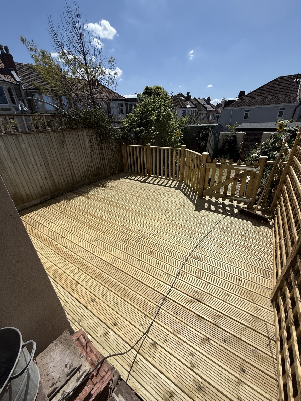 Timber decking viewed from above with side gate and fencing