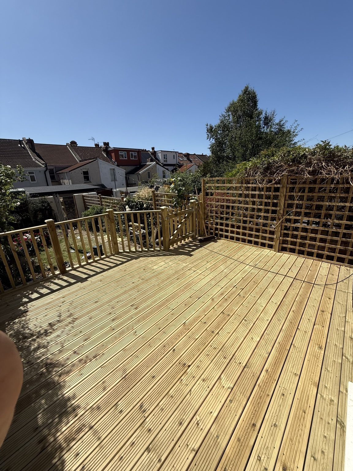 Wide timber decked area with balustrade and gate